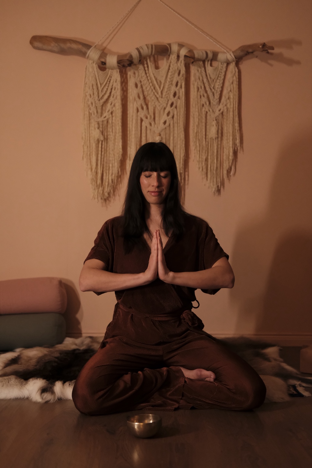 Hannah sitter i meditation med händerna sammanförda
